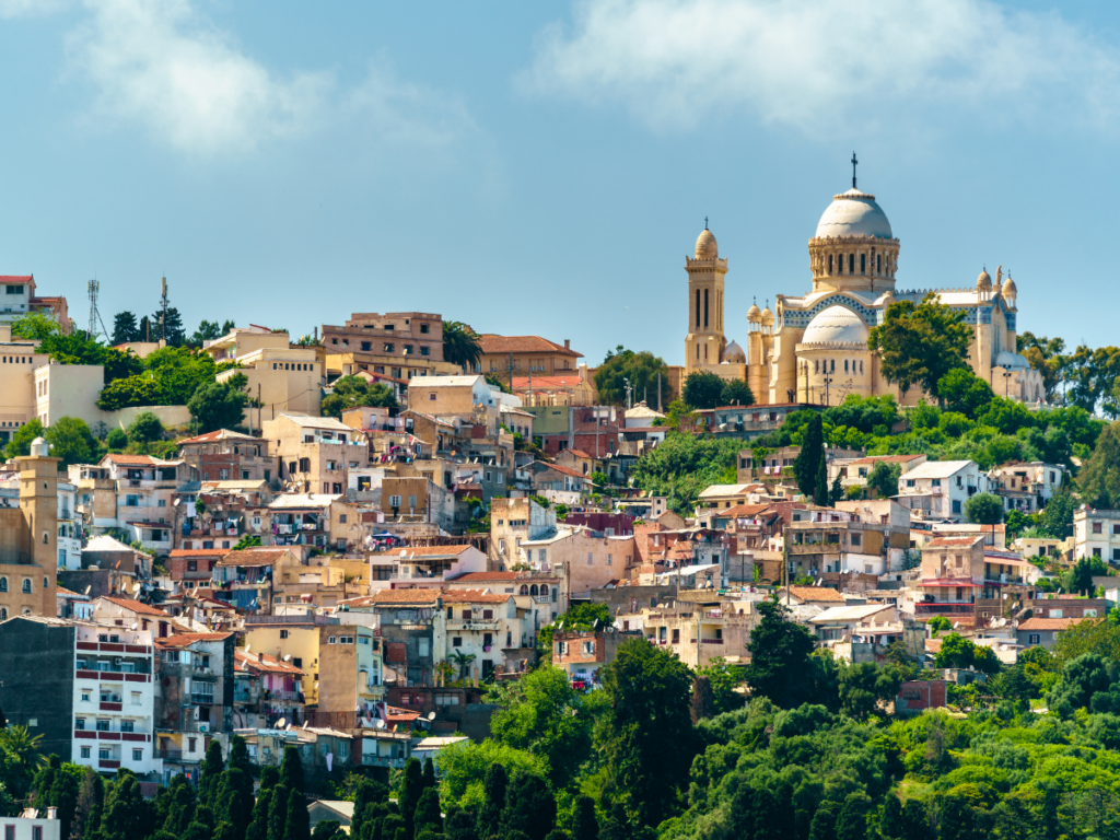 Vue urbaine d’Alger avec la basilique Notre-Dame d’Afrique dominant les quartiers résidentiels, destination clé des vols France Algérie.