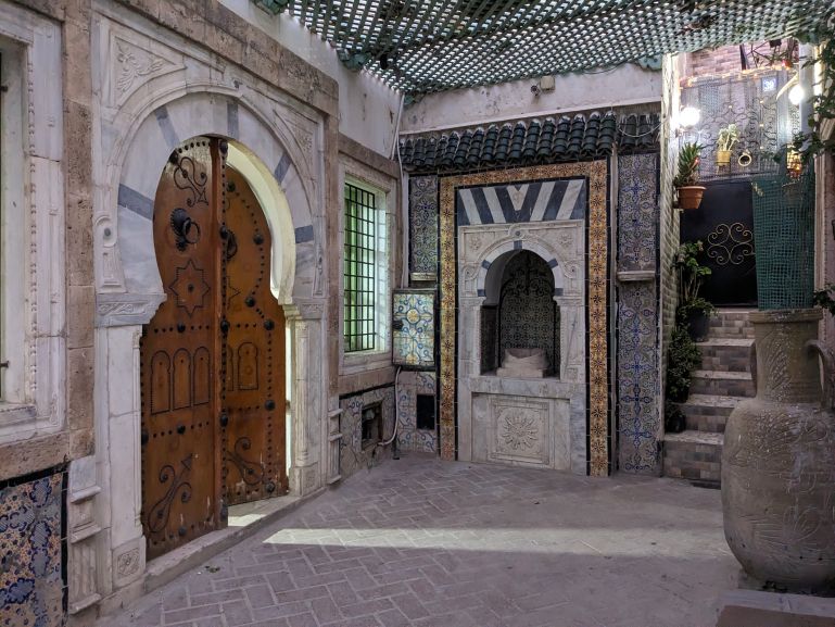 Cour cachée derrière porte traditionnelle dans la médina de Tunis, voyage Paris Tunis