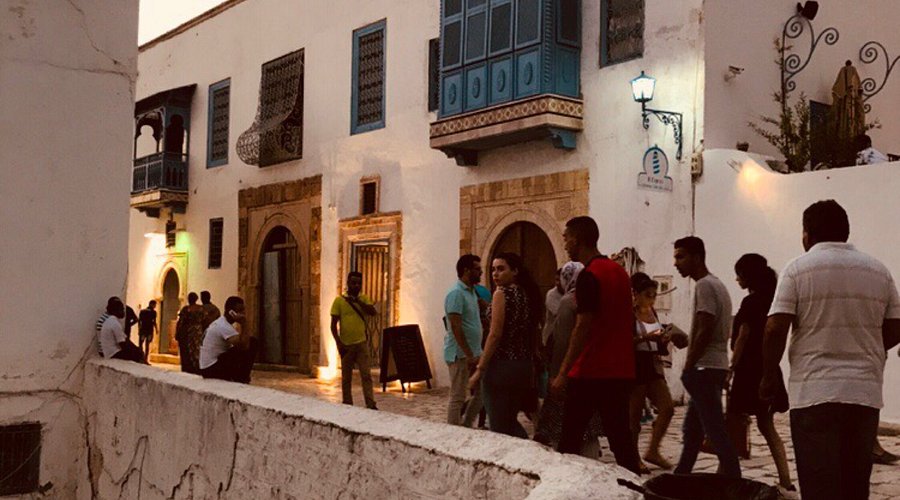 Ruelle animée de la médina de Tunis au crépuscule, vie locale authentique